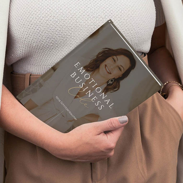 Buchcover Emotional Business Code in Erdtönen mit Bild von Autorin gehalten von einer Frau