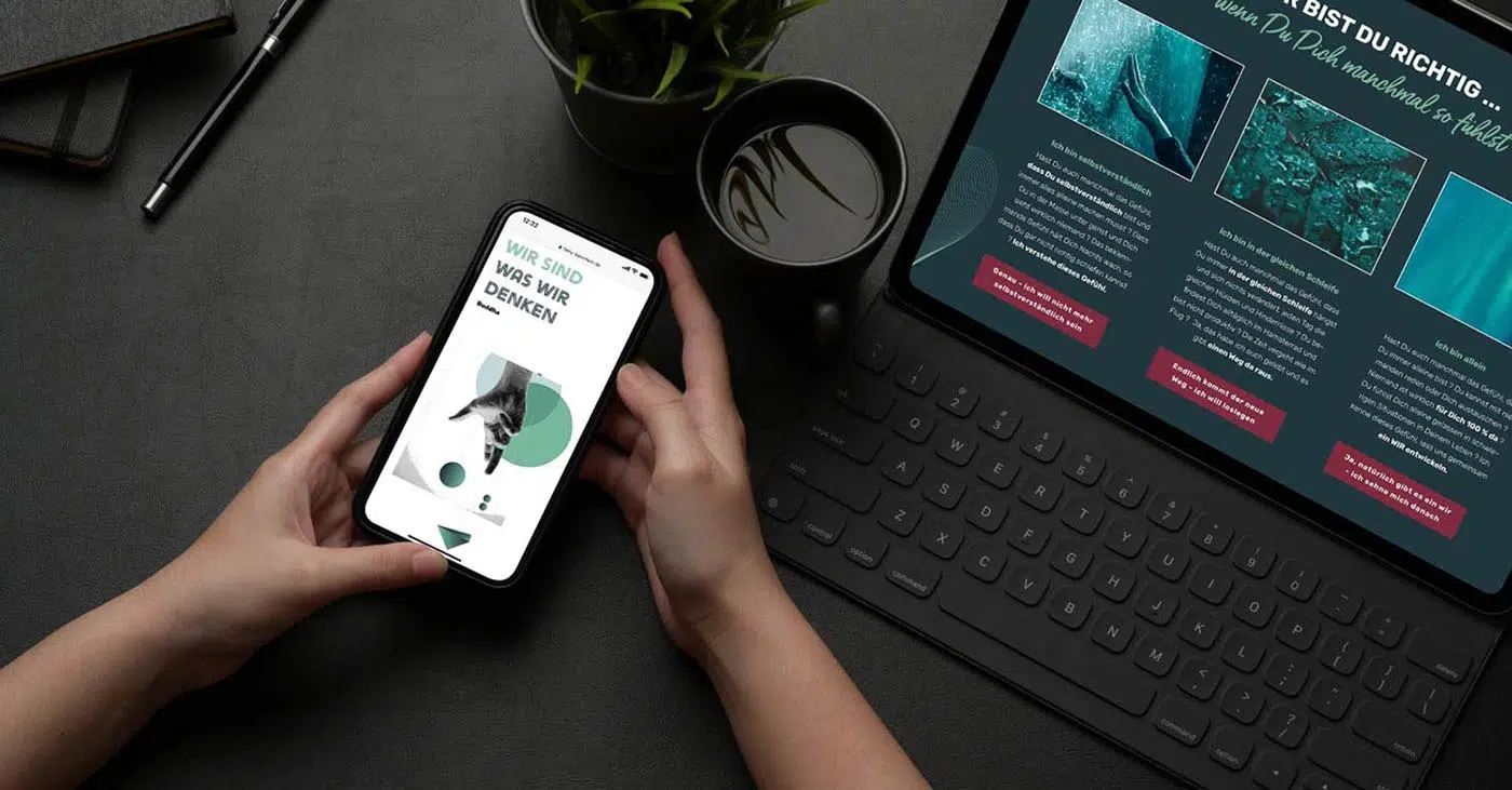 Tisch in schwaz mit Laptop und Mensch, der ein Handy in der Hand hält. Auf dem Handy eine Seite in weiß mit grafischen Mustern in grün und grau und einer Hand, die nach einem der Elemente greift. Text in abgestuften grün Tönen gehalten. Auf dem Laptop zu sehen auf dunklem Hintergrund dunkel, 3 Fotos mit jeweils Text darunter. Alles sehr mystisch anmutend